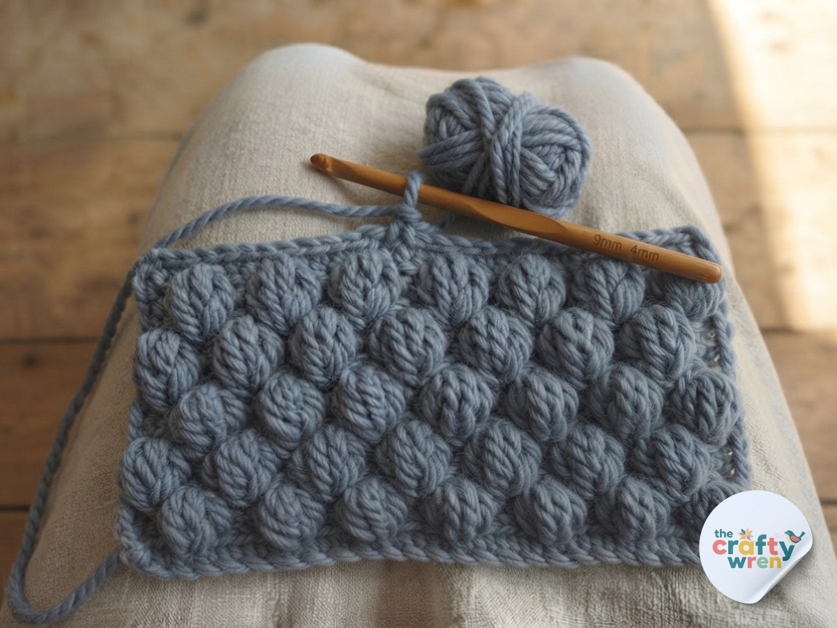 A lap-sized panel of densely clustered puff stitches showing the full floral texture of the crochet blanket.