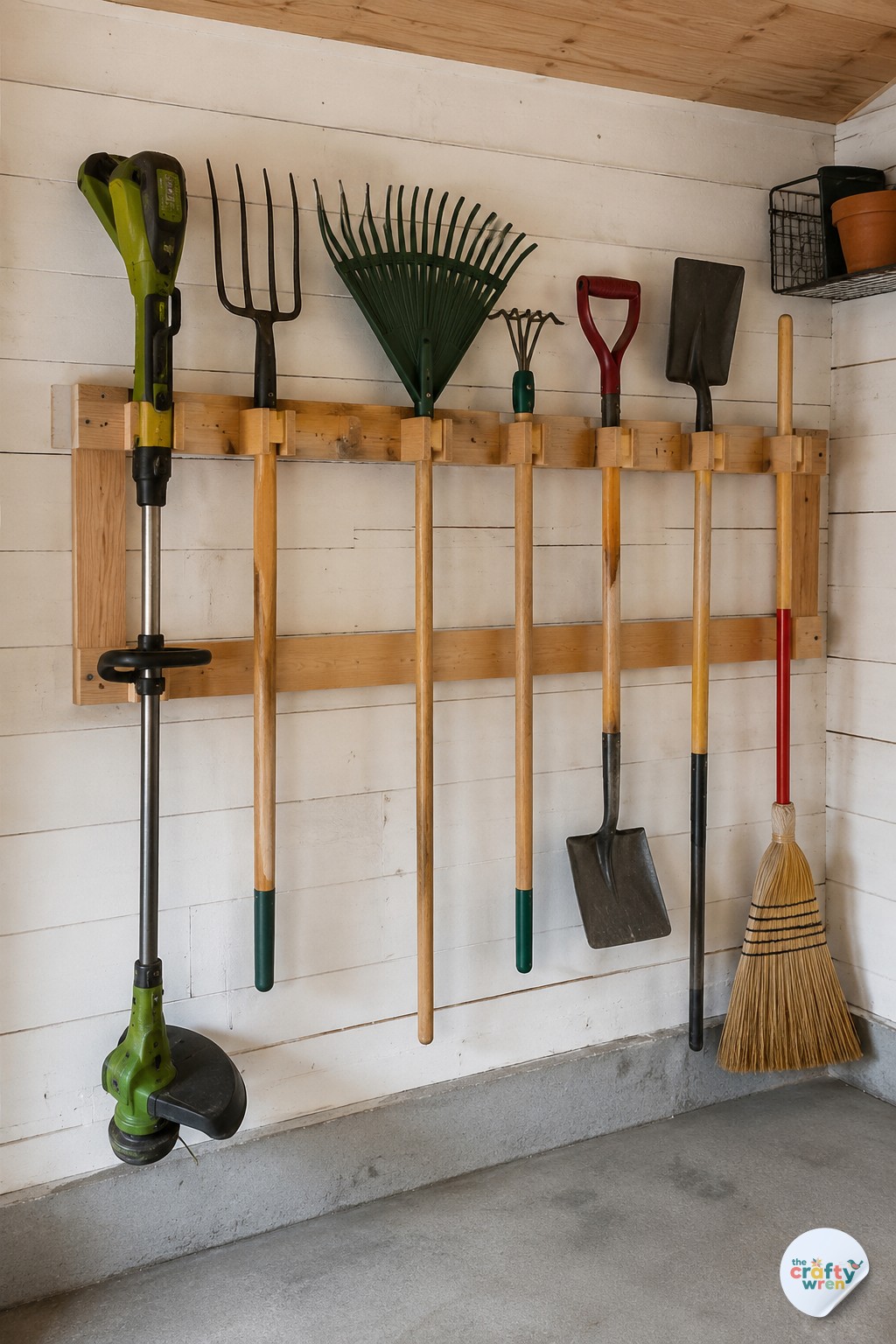 Simple wood-plank rack mounted on a wall offering budget garage storage for long tools