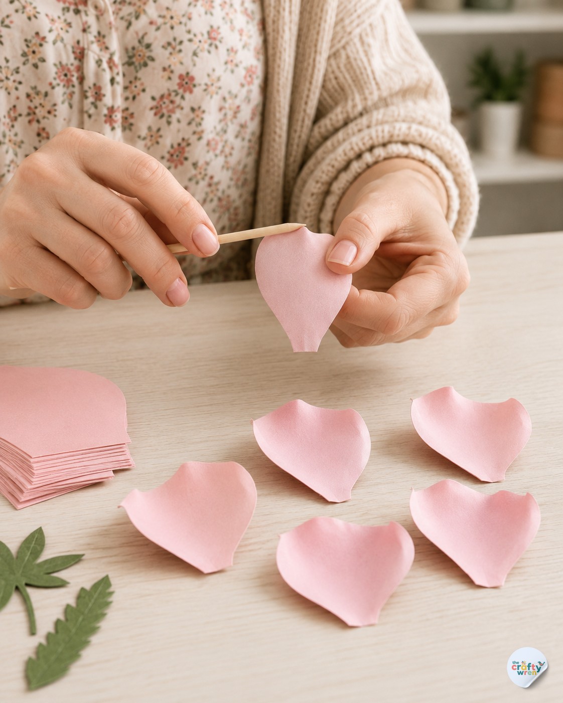 Curling pink paper petals with a wooden skewer for a handmade paper rose bouquet DIY